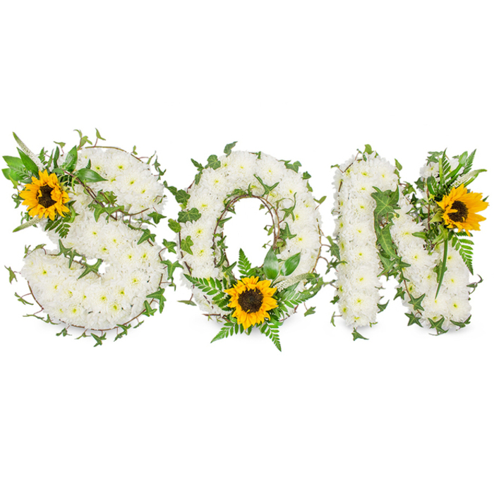 A three-dimensional memorial arrangement photographed against a pure white studio backdrop: the word SON rendered in firm capital letters and densely blanketed with small, pristine white chrysanthemums whose velvety petals form a continuous, tactile surface. Woven through the white blooms are sinuous strands of dark green ivy with characteristic pointed leaves, together with lighter green fern fronds and assorted leafy sprigs that create depth, shadow, and natural contours across each letter. To introduce a bright, consoling accent three large sunflowers are strategically placed-one set into the upper-left curve of the S, a second positioned at the bottom center of the O where it breaks the circle, and a third adorning the upper-right of the N-their bold yellow petals and textured dark brown disks commanding the eye and adding a sense of warmth to the composition. The contrast between the soft white chrysanthemums and the vibrant sunflowers is deliberate: white for calm and respect, green for growth and continuity, yellow for fond recollection and light. As a Golders Green florist accustomed to preparing funeral tributes and commemorative letters for families near Golders Green Road and Golders Green Crematorium, I chose materials that wear well in procession and photograph easily for memorial programs. The subtle scent of fresh chrysanthemums and cut foliage remains understated, while the arrangement's clean lines and carefully placed accents communicate love, honour, and quiet celebration of a son's life.