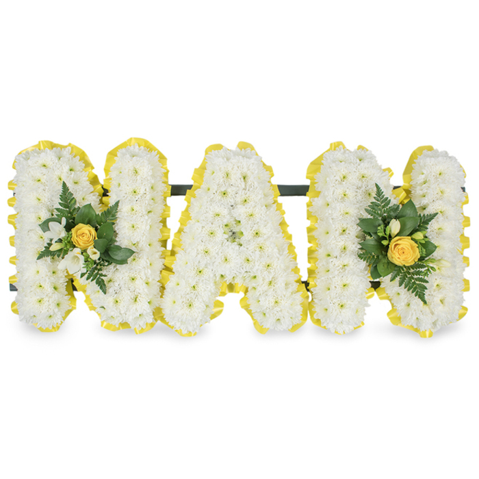 A vibrant, lovingly fashioned floral tribute spells out the letters MAM in three distinct capital forms, each letter completely smothered in small, immaculate white chrysanthemum spray flowers that give a lush, tactile surface resembling spun silk. The clean outlines of each letter are traced with a cheerful yellow pleated ribbon, its crisp folds forming a bright border that contrasts beautifully with the white blooms. Two floral embellishments grace the composition: the left upright of the first M and the right upright of the second M each carry an elegant cluster centred on a soft, furled yellow rose bud, accompanied by tiny white freesia-like blooms and an assortment of deep green foliage including slender fern fronds and glossy leaves which add depth and a refreshing verdant note. A discreet, sturdy dark green or black bar runs behind the upper sections to join and stabilise the letters, suggesting a display built to stand or be propped for a memorial table or graveside setting. Photographed against a clear white background under gentle studio light, the piece presents high contrast and fine detail-the pleated ribbon catching highlights, the chrysanthemum petals forming subtle shadows, and the greenery providing cool counterpoints. This arrangement reads as both dignified and warm: white to signify purity and remembrance, yellow to convey affection and sunlight. It is an intimate, personalised tribute suitable for funeral services, memorial gatherings or as a graveside homage to a beloved mother figure, and carries the quiet craftsmanship one expects from an experienced florist serving the Golders Green community, from Hoop Lane to Finchley Road.