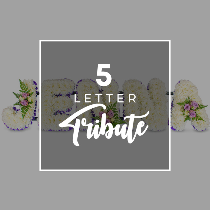 A refined and deeply personal five-letter floral tribute is displayed against a calm, light grey backdrop, similar to the bespoke funeral pieces prepared for families around Golders Green and Temple Fortune. The arrangement is composed of large, freestanding letters laid in a row, each one densely carpeted with fresh white chrysanthemums or carnations. Their tightly packed blooms create a plush, gentle texture that communicates purity and quiet respect. Around the perimeter of every letter, a band of dark purple satin ribbon has been carefully pinned in place, its rich colour and slight sheen adding both contrast and a formal, respectful framing to the soft white flowers. Scattered thoughtfully across the letters are small, artfully arranged clusters of accent blooms: pale pink and mauve spray roses, accompanied by feather-light fern fronds and sprigs of green foliage. These details add depth and natural variation, suggesting delicate garden scents and the comforting presence of living plants. The letters visible behind the central text overlay appear to indicate the name JOHN plus an additional A, illustrating how this design can be customised to spell a five-letter name or heartfelt word for a funeral, memorial, or chapel service in the local area. In the middle of the image, a slightly darker grey square panel framed in white partially obscures the flowers. On it, minimalist white lettering reads 5 LETTER in crisp capitals, placed above the word Tribute in a flowing script that softens the composition. Gentle, even lighting ensures every petal, ribbon edge, and rose cluster is clearly defined, creating an overall impression of calm remembrance and carefully crafted, personalised farewell flowers.
