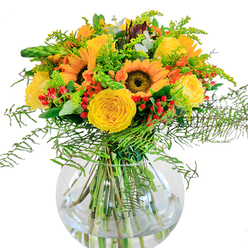 In this luminous bouquet, large sunflowers, their ochre-gold petals encircling rich cocoa centres, command attention like bursts of sunshine found amid the gardens and streets of Golders Green. Around them flow rosettes of soft yellow roses, each bloom opening with elegant, spiraled layers, echoing the classic charm of North West London homes. Scarlet hypericum berries are sprinkled throughout, playful and lively, lending a spirited contrast to the golden hues and lush greenery. Fern fronds and goldenrod weave gracefully among the flowers, their slender, feathery leaves reminiscent of Hampstead Heath's gentle undergrowth. Bluish-green eucalyptus adds a subtle cool tone and silvery sheen, catching the eye and the nose with its crisp scent. Arranged thoughtfully in a round, fishbowl-style vase, the stems are visible in sparkling water, conveying a sense of fresh-picked abundance from a Golders Green florist's bench. Imagine this arrangement as the heart of a celebration-perhaps a birthday or anniversary-its fragrance and colour mingling with laughter and light streaming through a local bay window. The bouquet invites admiration whether set on a festive table, delivered to a friend's home on Hoop Lane, or brightening a workspace nearby. Crafted with care and an eye for seasonal harmony, this floral composition is as welcoming and vibrant as Golders Green itself-ready to lift spirits and create cherished memories for residents and visitors alike.
