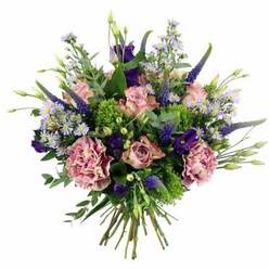 An abundant, dome-shaped bouquet sits centre stage against a pure white background, its colours echoing the gentle, refined side of Golders Green. The design is led by soft pastel roses in shades of blush pink and pale mauve, some tightly spiralled, others more fully opened so that their velvety petals form intricate rosettes. Interwoven with them are generous carnations in dusty rose and muted purple tones, their deeply ruffled petals giving the arrangement a plush, almost fabric-like depth. Shooting upwards through this soft mass of petals, elegant wands of deep indigo and violet Veronica introduce a touch of drama, adding vertical lines that prevent the bouquet from feeling too traditional. Around these, clusters of rich purple lisianthus and delicate, daisy-like lavender asters with tiny yellow centres provide playful highlights, like wildflowers gathered from a stroll through nearby Golders Hill Park. Fresh foliage in a spectrum of greens supports and brightens the composition: chartreuse, mossy textures mingle with smooth, silvery eucalyptus leaves and deeper green sprigs, creating a vivid backdrop that keeps the colours looking fresh and lively. The stems are clearly visible at the bottom, pulled together in a tidy hand-tied bundle, suggesting a florist's careful touch and readiness for delivery to a home or office near Temple Fortune or along Finchley Road. In this image, you can almost imagine the soft fragrance of garden roses blending with clean, green notes from the foliage, evoking a mood of thoughtful celebration suitable for birthdays, anniversaries, or simply sending love across Golders Green.