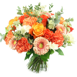 A vibrant, hand-tied bouquet pictured against pure white, assembled in a classic rounded silhouette that feels at once elegant and warmly familiar to residents of Golders Green. Several large roses form the focal points-some in rich, fiery orange, others in a sunlit golden yellow-their tightly spiralled petals and full heads lending a luxurious, tactile centre. Coral and burnt-orange carnations nestle densely between the roses, their ruffled layers building softness and volume, while peach-toned gerbera present flat, open faces with subtle greenish centres that add a contemporary pop. Scattered among these are delicate white filler blooms-small spray flowers or freesia-like accents-that lighten the composition and lift the warm palette. Pale green, starry filler clusters reminiscent of astrantia peek through for a gentle, feathery texture, and rounded eucalyptus leaves in silvery grey-green are threaded throughout to give depth and a cool counterpoint to the warmth. The stems are neatly gathered and tied, demonstrating handcraftsmanship and freshness. I can almost smell the heady sweetness of the roses tempered by the citrusy-green breath of eucalyptus. This bouquet, arranged and ready for a glass vase, is perfect for birthdays, anniversaries, or a cheerful get-well delivery; at Flowers Golders Green we often send similar designs across the NW11 area for same-day delivery to homes and offices near Golders Hill Park and Golders Green Tube. The overall impression is one of approachable luxury-seasonal, comforting and crafted with local care.