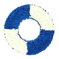 Set against a bright white background, this striking circular floral tribute is carefully designed to mirror the shape and markings of a maritime life ring, creating an immediate sense of symbolism and meaning. The wreath is composed entirely of tightly clustered, small-headed flowers, likely fresh chrysanthemums, which together form a smooth, cushion-like surface with gentle undulations where the petals overlap. The ring is divided cleanly into four equal quadrants: two sections of intense royal blue blooms alternating with two sections of pristine white flowers. The blue areas are rich and saturated, resembling the depth of open water, while the white segments appear luminous and pure, echoing breaking waves or sea foam. In the centre, the circular opening is neatly defined, its edge trimmed with a slim band of dark blue ribbon, lightly pleated to add a delicate, textile texture that complements the flowers without overpowering them. There is a serene, contemplative quality to the image, with no background clutter to distract from the careful geometry and strong colour contrast. This floral life ring feels like a fitting tribute for a funeral or memorial in and around Golders Green, perhaps chosen by a family remembering a sailor, lifeguard, or someone who devoted their life to helping others. Crafted with the care you would expect from an experienced local florist, the design would sit beautifully beside a coffin, on a stand at Golders Green Crematorium, or at a graveside, quietly conveying ideas of protection, guidance, and a final safe passage home.
