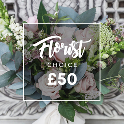This bouquet reads like a small, trusted memory from a neighbourhood garden: a dense cluster of soft blush roses set against airy sprays of white berries and meadow-like filler, arranged to feel both refined and freshly gathered. The rose heads open in gentle spirals of palest pink, their velvety petals catching a mellow, diffuse daylight that enhances their romantic warmth. Interspersed among them are dusky, blue-green eucalyptus leaves whose rounded forms and silvery sheen provide a cool counterpoint, carrying a subtle, refreshing scent that lifts the composition. Fine clusters of tiny white flowers-resembling waxflower or astrantia-create an impression of delicate snowfall, while touches of deeper pink and burgundy add shadow and nuance. Upright green-and-white spikes, similar to snapdragon stems, create vertical rhythm at the edges, giving the bouquet a graceful silhouette. Bright white snowberries or hypericum berries dot the arrangement like little lights, and the stems are gathered and tied with a cream satin ribbon, the finish neat and tactile. Presented in soft ambient light, the bouquet feels calming yet enlivening-ideal for welcoming someone to a new home, sending sympathy with understated kindness, or marking a quiet anniversary. As a local florist I imagine delivering this arrangement across Golders Green-down Golders Green Road, past the shops near Finchley Road or after a stroll through Golders Hill Park-each stem selected for freshness and thoughtful composition. Flowers Golders Green crafts it to arrive smelling faintly of eucalyptus and morning air, a handcrafted choice made to comfort and delight.