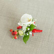At the heart of this handcrafted boutonniere sits a pristine white phalaenopsis orchid, its broad, velvety petals opening like a soft silk blossom with a warm yellow-orange throat providing a delicate focal note. Encircling the orchid, the feathery clusters of gypsophila create a dreamy, cloud-like texture, their tiny white blossoms whispering romance and lightness around the central bloom. Bright red hypericum berries are artfully tucked among the blooms; their glossy, firm skins bring a lively punctuation of colour and a hint of rustic cheer. Pale green elongated buds - perhaps unopened hypericum or tender foliage shoots - offer a suggestion of growth and the promise of fuller bloom. Slick, deep green leaves with a gentle sheen cradle the composition and give it depth, likely salal or similar smooth-edged greenery, their cool tones balancing the warm ribbon and berries. The boutonniere rests on a warm, light beige woven fabric background which lends a subtle textural contrast to the soft petals and satin ribbon. The stems are lovingly bound with a rich red satin ribbon tied into a small knot with a short tail angled to the right, the fabric reflecting the light for an understated shine. In the quiet, attentive light, you can imagine the cool touch of petals, the satiny weight of the ribbon, and the faint, powdery scent of Baby's Breath intertwined with orchid's delicate perfume. Designed with weddings and milestone celebrations in mind, this piece would suit a civil ceremony near Finchley Road or an elegant reception by Golders Hill Park, offering a restrained, joyful accent that reads as both modern and timeless.