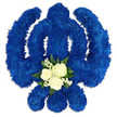 A bold and reverent Sikh Khanda-shaped funeral tribute fills the image, carefully constructed from a dense blanket of deep royal blue flowers that stand out dramatically against a bright white background. The iconic Sikh emblem is instantly recognisable: the central upright sword, framed by the circular chakkar and embraced by two gracefully curving kirpans, all rendered in meticulously placed blue chrysanthemum heads. The petals create a soft, plush texture, with subtle variations in tone adding depth and movement, like ripples of midnight blue fabric. At the lower centre, where the eye naturally settles, a delicate grouping of white flowers offers a moment of softness and light. Three ivory-white roses, blooming in full, are gathered closely together and framed by tiny stars of baby's breath and a neat border of glossy green leaves. The interplay of blue, white, and green suggests devotion, remembrance, and hope-sentiments that resonate deeply for Sikh families in the Golders Green area saying goodbye to a loved one. Gentle shadows beneath the arrangement give a sense of weight and three-dimensional presence, as though the tribute is resting on a stand in a quiet room near Golders Green Station, ready for a final journey to the gurdwara or crematorium. This floral Khanda feels both traditional and deeply personal, the kind of bespoke sympathy piece crafted by Flowers Golders Green for families who wish to honour their heritage, faith, and the memory of someone cherished with a meaningful, visually powerful tribute.