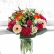 A scene of happiness and luminous colour unfolds in this Golders Green bouquet-a joyful celebration captured and held together by expert hands. Spirited orange gerberas reach outward in exuberant arcs, radiating heat and optimism that's reminiscent of summer afternoons spent in Golders Hill Park. Nestled among them are blushing pink roses and deep magenta carnations, their velvety silhouettes rich with promise and affection. Creamy ivory roses and gentle peach gerberas balance the display, lending a whisper of elegance and softness that soothes the senses. The vivid greens, gleaming and lush, frame the arrangement perfectly, grounding it in a sense of Golders Green's natural abundance. Sunlight pours in, almost ethereal, lighting each petal and sending the bouquet's saturated colours dancing-a perfect visual to lift spirits on Finchley Road or mark milestones for loved ones near Temple Fortune. More than mere decoration, it's a burst of happiness and harmony-a gift that feels personal and seasonally attuned, crafted with the awareness and care one expects from Flowers Golders Green.