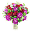 A rich, rounded bouquet of deep red roses and vivid magenta-purple carnations sits in a clear glass vase against a clean white background, the composition radiating warmth and joyful energy. Each rose shows a range of openness-some tightly furled, others unfurling to expose velvet-thick spirals of petal-their crimson surfaces catching soft highlights that suggest a gentle, natural light. Interspersed among them are clusters of ruffled carnations in an almost fuchsia-leaning purple; their frilly edges and layered petals add buoyant texture and a playful movement that contrasts beautifully with the roses' smooth surfaces. Bright, glossy foliage-reminiscent of ruscus-builds a verdant foundation, its deep green leaves reflecting light with a fresh sheen, while slender sprays of silvery-green eucalyptus lift the arrangement with a modern, slightly aromatic air. The stems are visible through the transparent vase, lending an honest, botanical clarity and a homey, freshly-gathered feel. The overall shape is compact and generous, a full, abundant cluster that reads as both celebratory and intimate. Fragrance is implied-a soft mingling of rose sweetness and green eucalyptus brightness-inviting the imagination to lean closer. This bouquet suits a range of heartfelt moments: an anniversary table, a birthday surprise, or a delivery to mark a meaningful congratulations. As a local florist might note, its confident colour pairing and tactile contrasts make it a memorable gift for someone who appreciates classic romance with a spirited, contemporary twist. The white backdrop ensures the saturated reds and purples pop, emphasizing the bouquet's freshness and polished presentation for any special occasion in Golders Green and nearby streets.