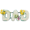 A three-dimensional memorial display spells out the word DAD in large, freestanding capital letters, each letter built from a dense carpet of pristine white spray chrysanthemums that give the shapes a soft, pillowed texture. The outer and inner contours of every letter are neatly edged with a ruffled, deep green satin ribbon that cuts a crisp line against the white blooms and reads like a protective frame. Thin, dark-green metal support bars run horizontally behind the letters, visible in gentle shadow and lending a structural, gallery-like calm to the composition. The whole piece is photographed against a plain white background so the purity of the whites and the fresh sheen of the green border remain the focus. Each letter bears its own floral accent. The left D is warmed by a cluster of three to four bright yellow roses set on the upper left curve, accompanied by tiny white filler blooms-freesias or gypsophila-and fresh green foliage; two long, bare green stems arch upward from that cluster toward the centre. The central A is anchored low on its left leg by a refined spray featuring two deep purple to burgundy calla lilies, their trumpet forms offering a dignified focal point surrounded by small white accents and glossy leaves. The right D mirrors the left with another cheerful yellow-rose cluster on its upper right curve, balancing the tribute. There is a subtle, clean fragrance of freesia and rose, a quiet brightness that complements the sober purpose. As a funeral or memorial piece the arrangement reads as thoughtful and bespoke: white for peace, yellow for cherished memories, and purple for reverence, designed to give comfort during a goodbye and to honour a beloved father in a calm, considered way.