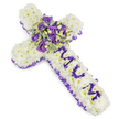 A tender, cross-shaped funeral tribute crafted from a dense carpet of pure white chrysanthemums sits against a clean white backdrop, the petals arranged so closely they form a pillowy, cushion-like surface that reads as both gentle and reverent. Around the perimeter a ruffled, deep lilac-to-purple satin ribbon is carefully pleated, its sheen catching soft light and framing the piece with a solemn, refined edge. Down the vertical arm the letters MUM are carefully formed from small, rich purple flower heads-likely lisianthus or spray chrysanthemums-each tiny bloom placed to create clear, dignified lettering that rises slightly above the white base. At the centre where the cross arms meet, a lush focal spray gathers deep violet and lavender roses with pale purple lisianthus and eustoma; their velvety petals range from duskier plum to soft lavender, offering a layered chorus of purple tones. Variegated green foliage-leaves edged in lighter green with darker centres, perhaps pittosporum-tucks around the cluster and provides a cool, textured contrast, while occasional round green berries add a small, natural punctuation of colour.

The overall mood is quietly consoling: the cool purples and pristine white suggest purity, respect, and gentle mourning. There is a faint, powdery scent of crushed petals and spring air, and the compact construction gives a sense of solidity and embrace. As a local florist familiar with Golders Green's compassionate funeral services near Golders Hill Park and the crematorium, I would choose this design to speak simply of love and remembrance when words feel too small.